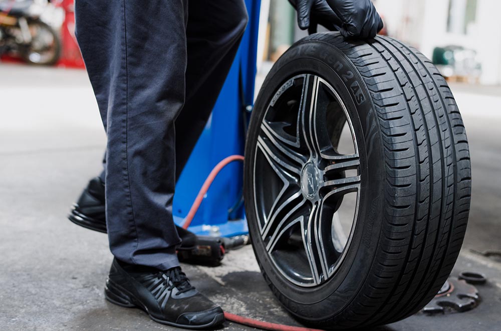 Technician inspecting a vehicle during an MOT test at Autotech Cheshire